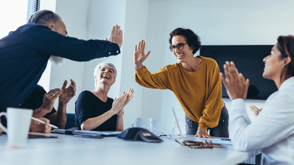 A smiling team high-fiving | When Do Facebook Ads Start Working?