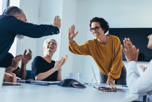 A smiling team high-fiving | When Do Facebook Ads Start Working?